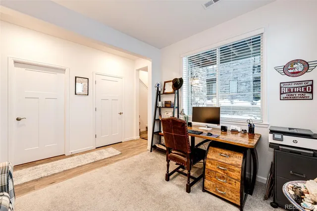 a view of a workspace with furniture and a window