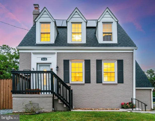 front view of house with a yard and plants