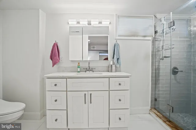 a bathroom with a shower sink and mirror