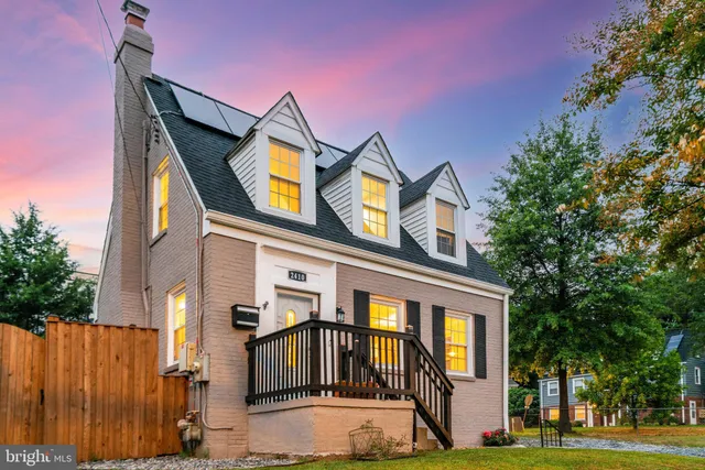 a front view of a house with garden and trees