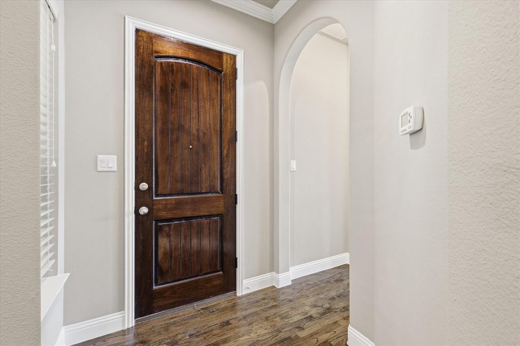 768 Huntingdon Street Coppell, TX 75019 - Photo 5 of 37 Step inside to a warm wood front door, neutral tones, crisp white trim, and rich hardwood floors that set the tone for the home.