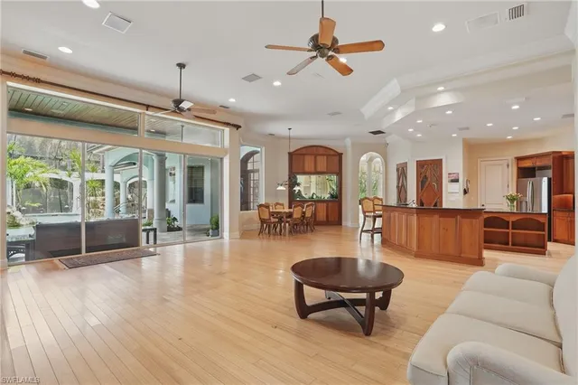 a living room with furniture a ceiling fan and a large window