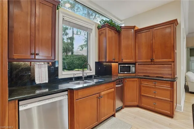 a kitchen with stainless steel appliances granite countertop a sink a counter space and cabinets