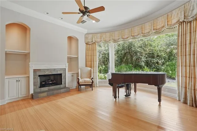 a view of a livingroom with a fireplace a chandelier and wooden floor