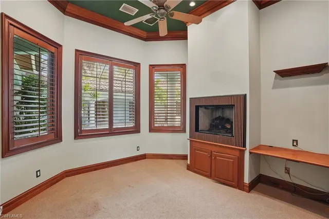 a view of an empty room with window and cabinet