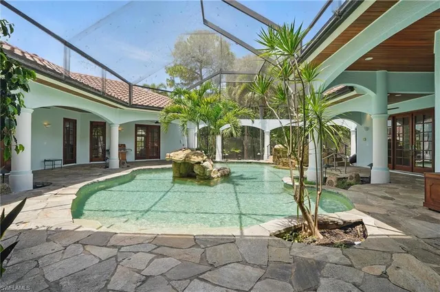 a view of a swimming pool with chairs in patio