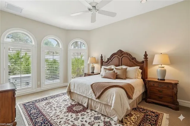 a bedroom with a large bed and three windows