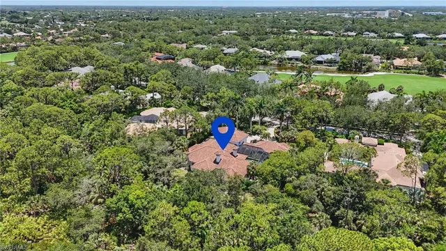 an aerial view of a house with a yard and trees