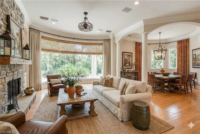 a living room with fireplace furniture and a large window
