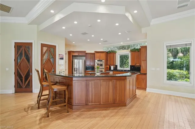 a kitchen with stainless steel appliances kitchen island granite countertop a table and chairs in it