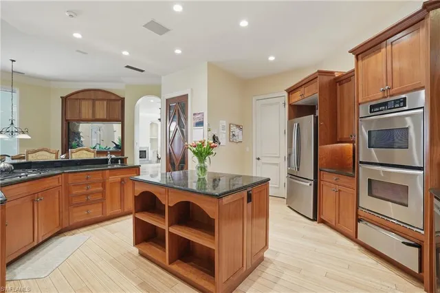 a kitchen with stainless steel appliances granite countertop a refrigerator and a stove top oven