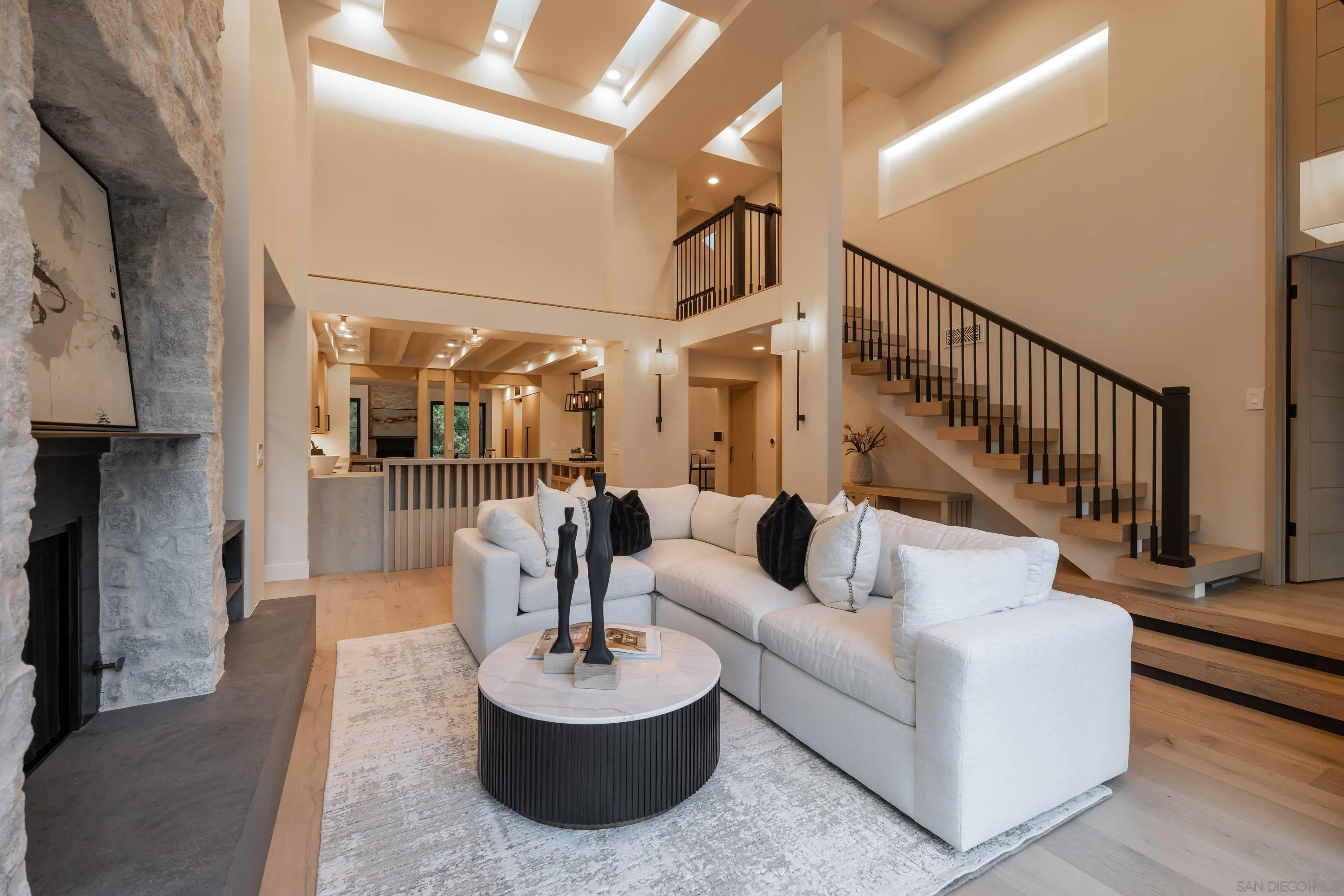 4954 Sun Valley Road Del Mar, CA 92014 - Photo 22 of 31 a living room with couches and a dining table with wooden floor