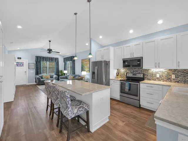 a kitchen with stainless steel appliances granite countertop a stove a sink refrigerator and a wooden cabinets