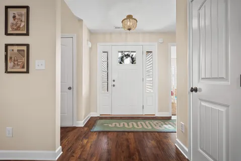 a view of a hallway with wooden floor and a large window