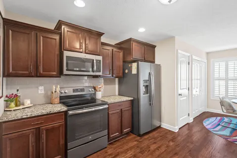 a kitchen with stainless steel appliances granite countertop a refrigerator stove and microwave