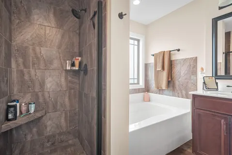 a bathroom with a tub sink and mirror