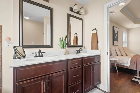 a en suite bathroom with a double vanity sink and a mirror