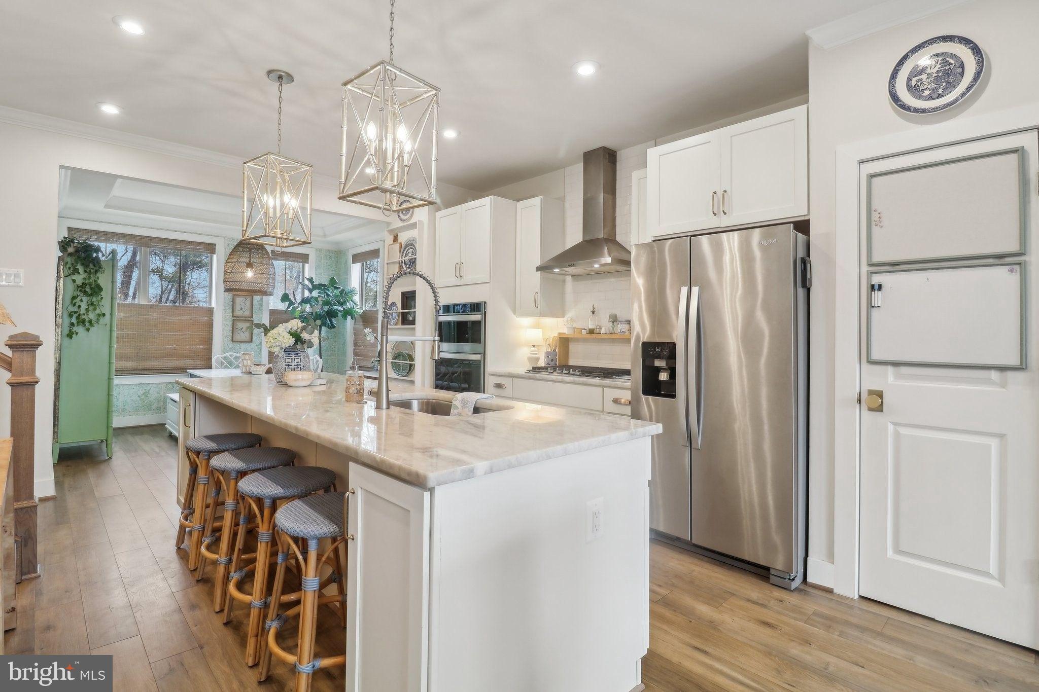 2256 South Glebe Road Arlington, VA 22206 - Photo 12 of 53 a kitchen with stainless steel appliances granite countertop a sink a stove a refrigerator and island with wooden floor