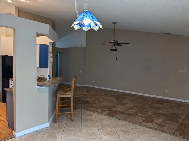 a view of a dining room with furniture and chandelier fan