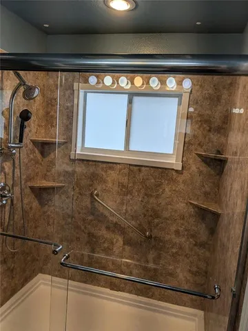 a bathroom with a granite countertop sink a light fixture and a mirror