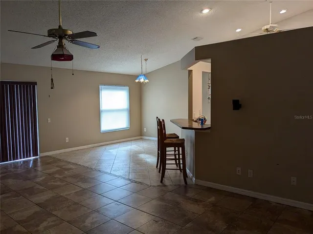 a view of a hallway with a dining table and chairs