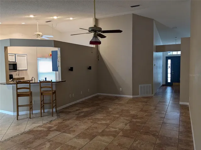 a view of a livingroom with furniture and kitchen view