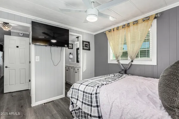 a bedroom with a bed tv and a window