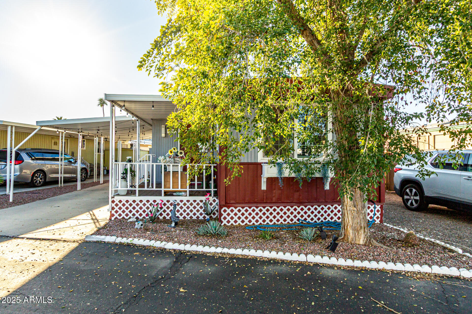 15606 South Gilbert Road, Unit 109 Chandler, AZ 85225 - Photo 2 of 49 a view of a brick house with large trees and wooden fence