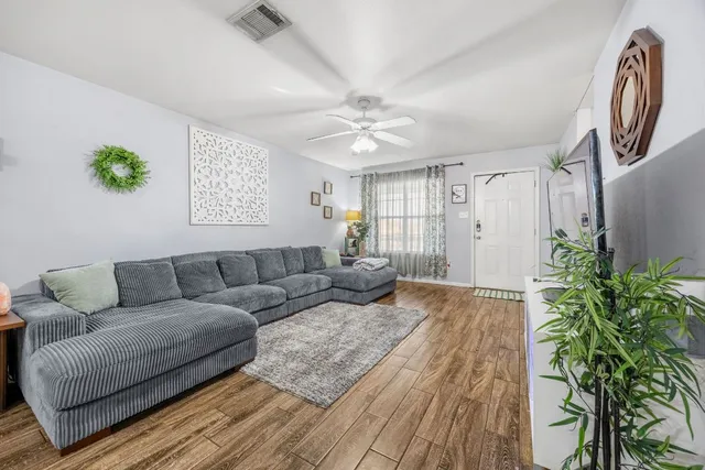 a living room with furniture fireplace and wooden floor
