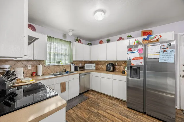 a bedroom with a bed potted plant on the dresser and a table