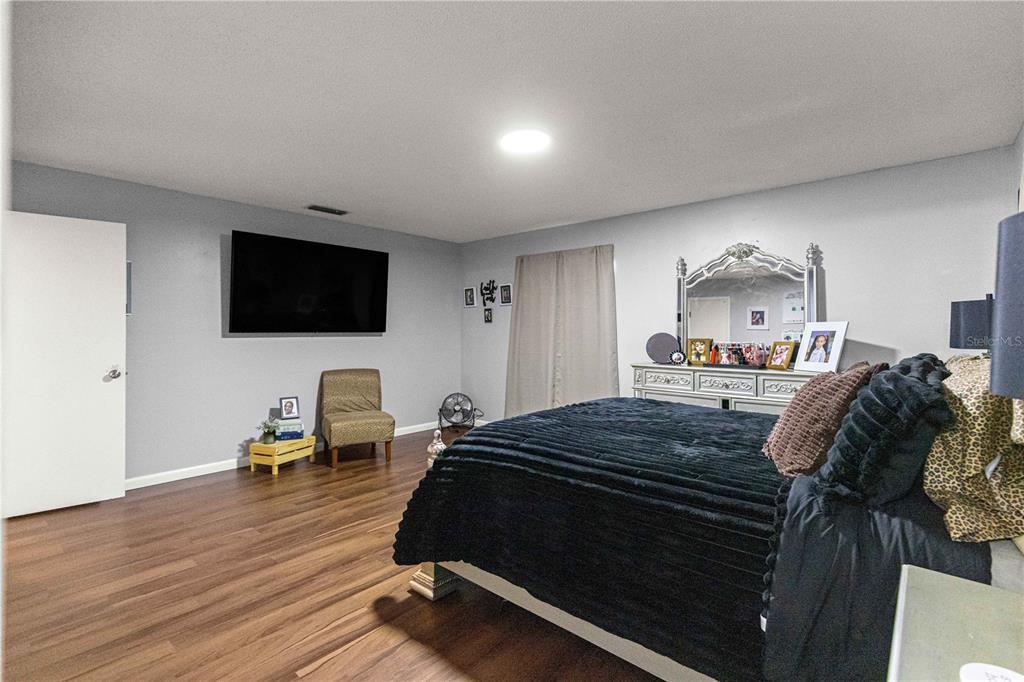 508 Emerald Road Ocala, FL 34472 - Photo 12 of 32 a bedroom with a bed and a flat tv screen on a dresser
