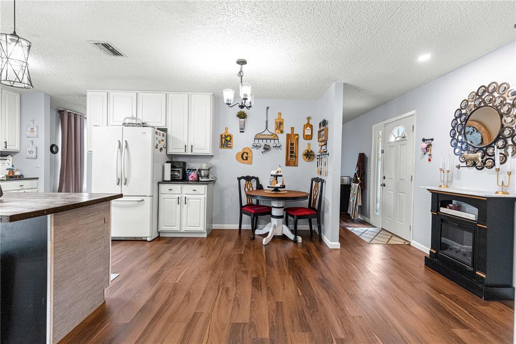 508 Emerald Road Ocala, FL 34472 - Photo 15 of 32 a kitchen with stainless steel appliances a refrigerator a stove top oven a sink dishwasher and a dining table with wooden floor