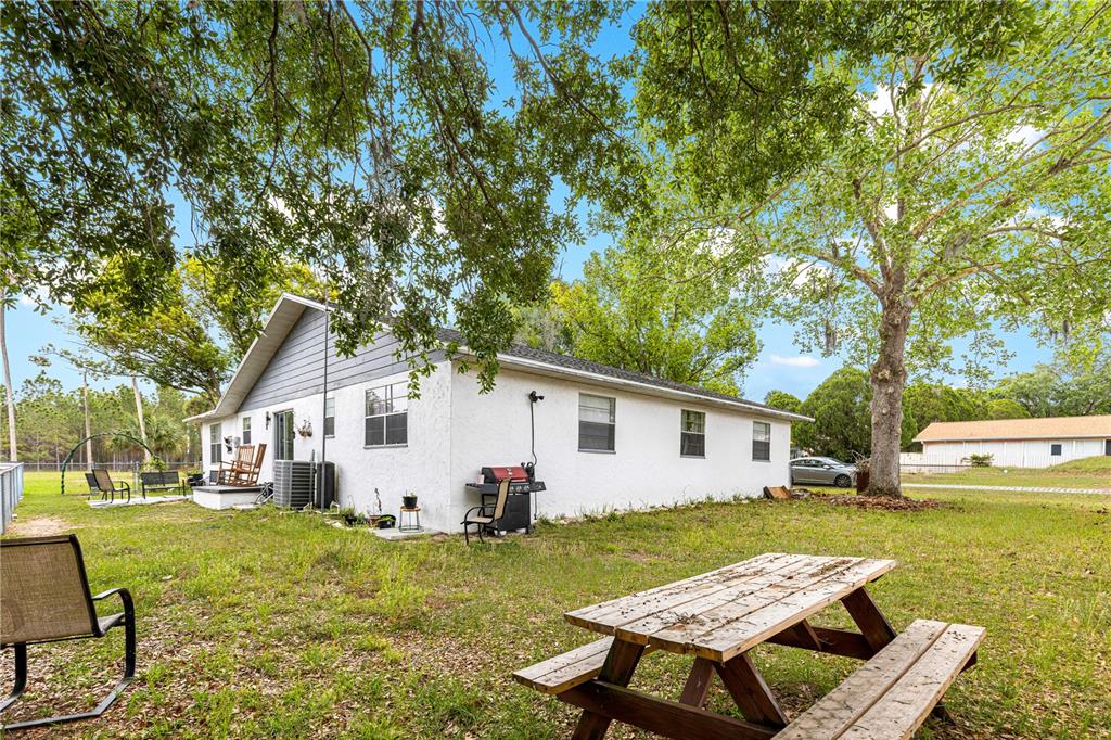 508 Emerald Road Ocala, FL 34472 - Photo 31 of 32 a view of a white house with a yard table and chairs