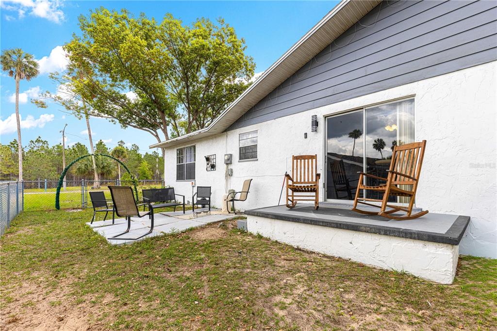 508 Emerald Road Ocala, FL 34472 - Photo 32 of 32 a view of a backyard with chairs and floor to ceiling window
