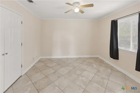 an empty room with windows and fan