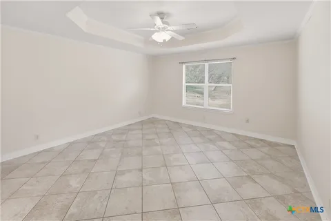an empty room with windows and ceiling fan