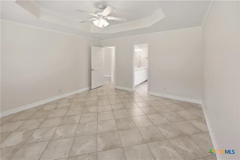an empty room with white walls and fan