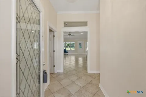 a view of a hallway with wooden floor and a bathroom