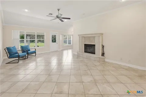 an empty room with windows and fireplace