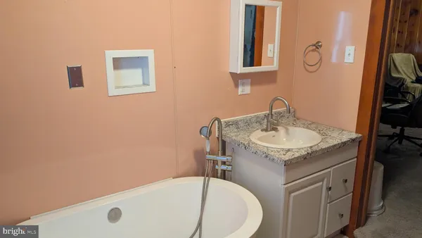 a bathroom with a granite countertop sink and a mirror