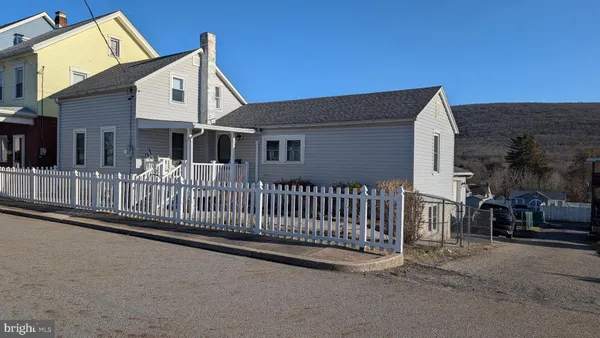 a view of a house with a small yard and wooden fence