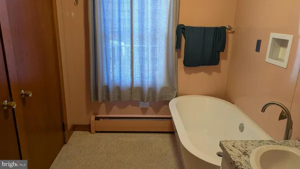 a bathroom with a tub and a mirror