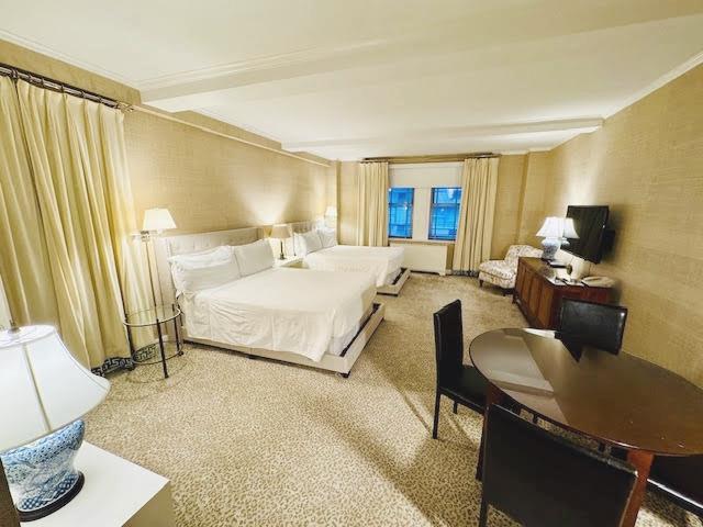 111 East 56th Street, Unit 712 Manhattan, NY 10022 - Photo 2 of 16 a bedroom with a bed and a couch