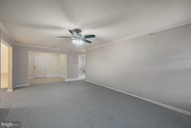 an empty room with a ceiling fan and a window