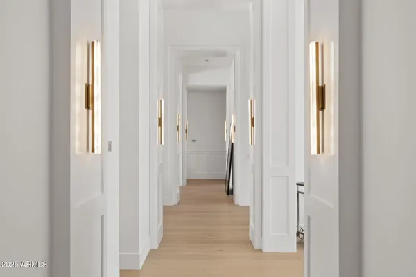 a large white kitchen with granite countertop a white cabinets and chandelier