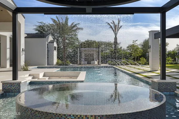 an empty room with a window and a chandelier fan