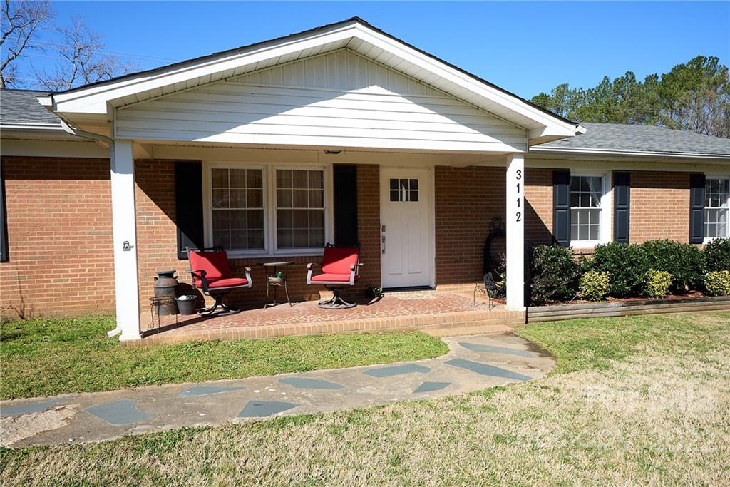 3112 Wolf Pond Road Monroe, NC 28112 - Photo 2 of 29 a view of a house with sitting area and garden