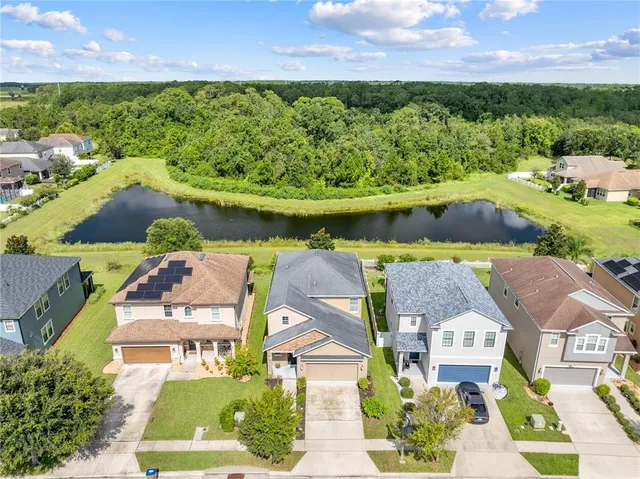 an aerial view of residential houses with outdoor space and swimming pool