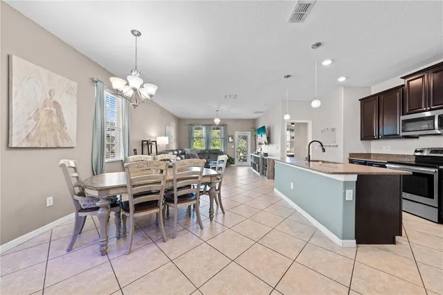 a kitchen with stainless steel appliances kitchen island granite countertop a refrigerator and a stove top oven