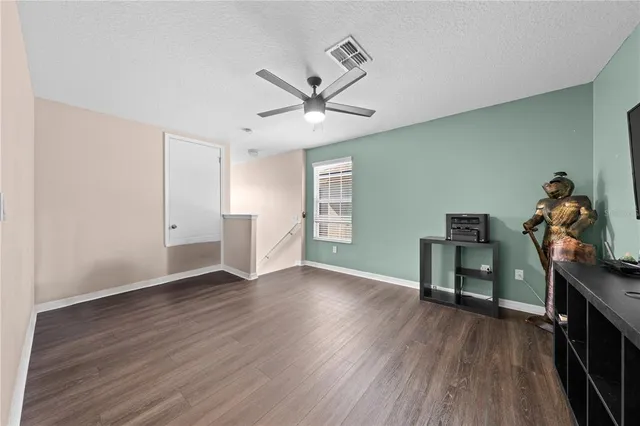 a room with wooden floor and windows